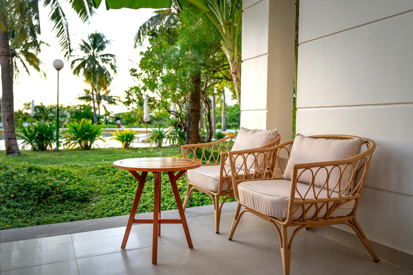 Rustige buitenruimte met natuurlijke tuinmeubels, stoelen en bijzettafel op een terras